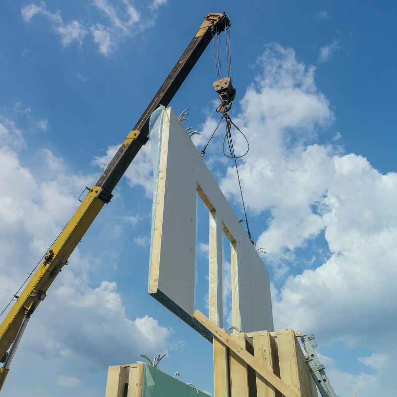Construction site with crane towing concrete element into place